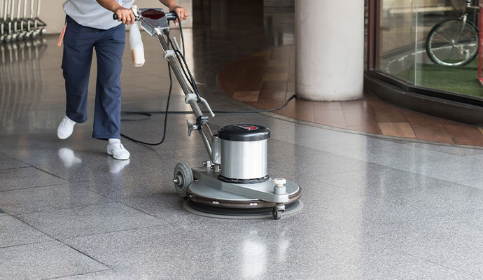 Professional floor cleaning service with machine in commercial building
